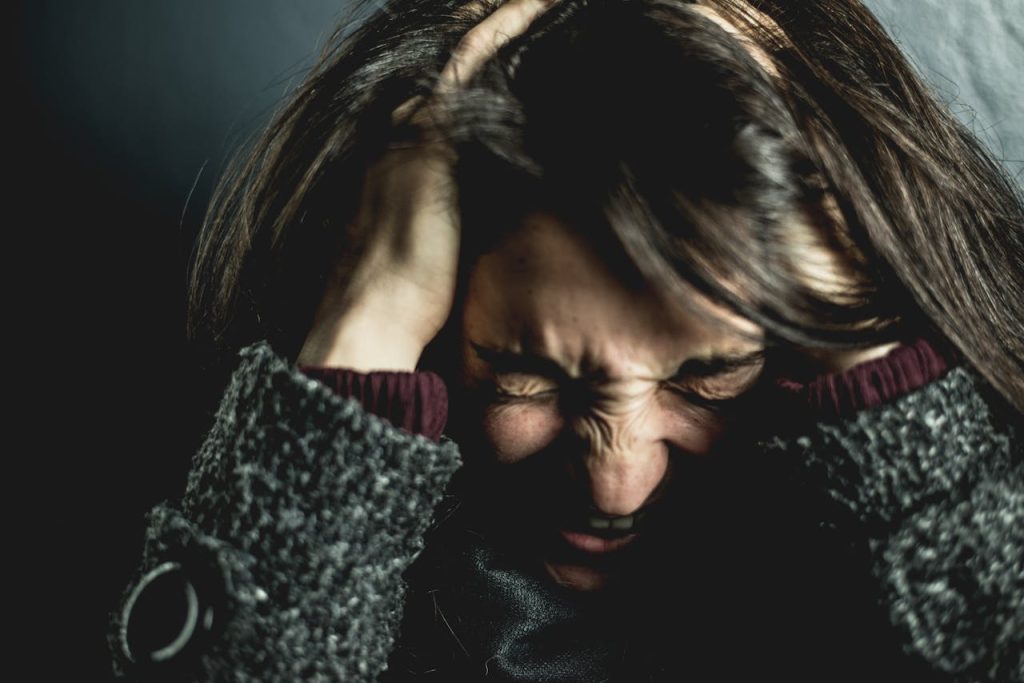 Mastering the First Impression: Your intriguing post title goes here Close-up of a woman in distress with eyes closed and hands in hair, expressing anxiety.